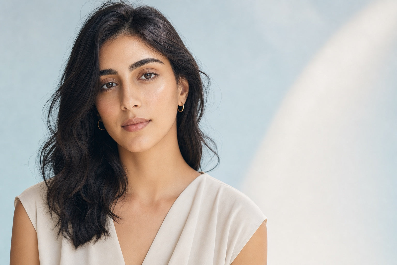 Middle Eastern woman with natural skin against a blue studio background for Orlena protocol guidance